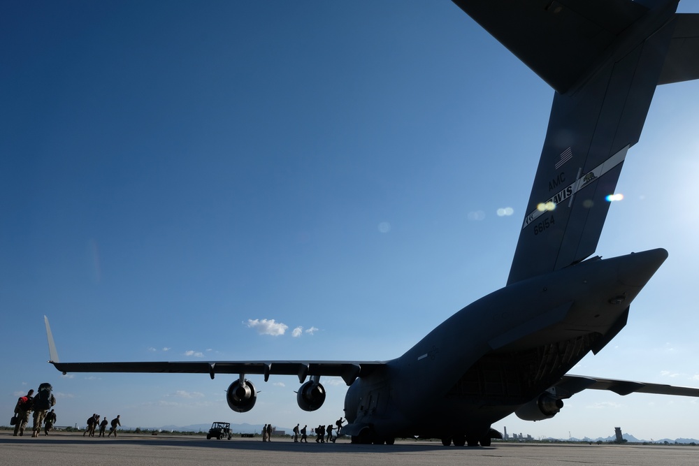 Members of the 306th Rescue Squadron board a C-17 Globemaster III for deployment