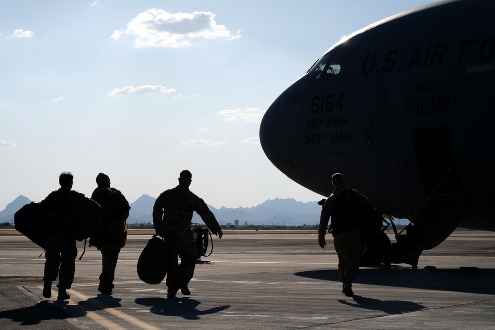 Members of the 306th Rescue Squadron board a C-17 Globemaster, headed for deployment