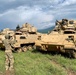 Soldier ground guides Bradley Fighting Vehicle during Saber Strike 19