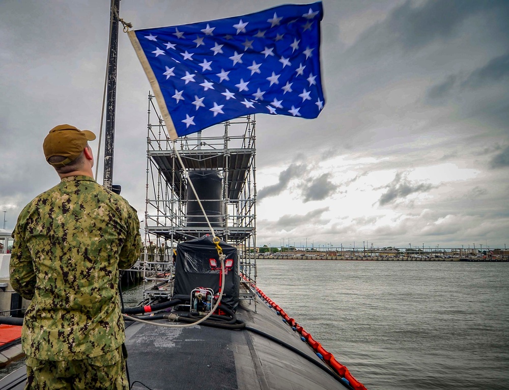A Sailor Hoists the Union Jack Aboard USS Albany