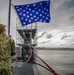 A Sailor Hoists the Union Jack Aboard USS Albany