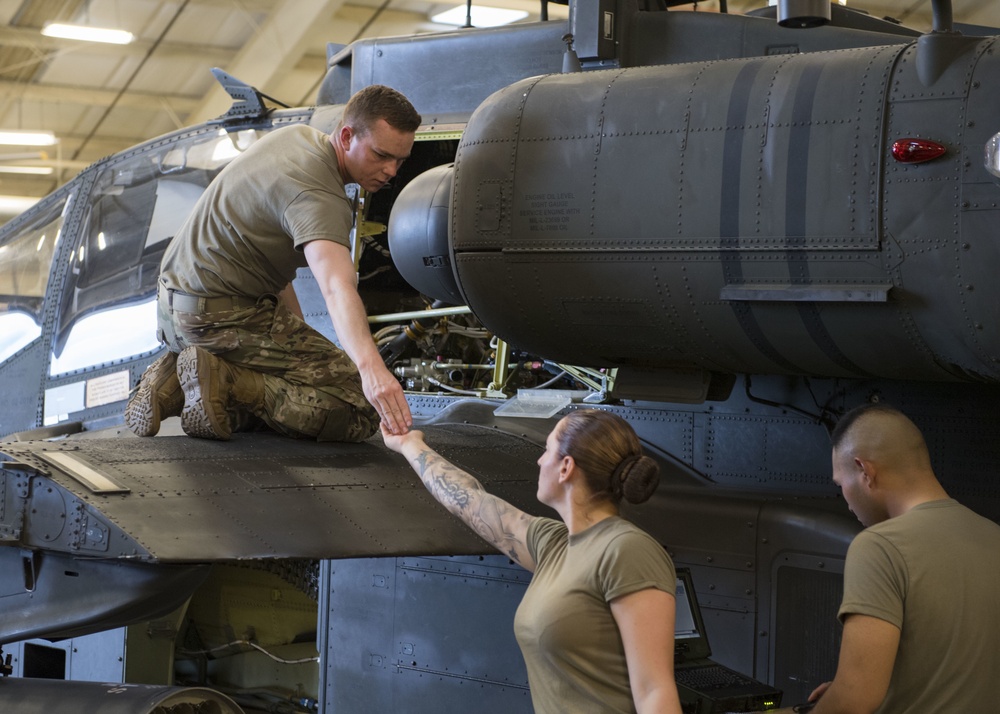 Soldier performing maintenance on Apache.