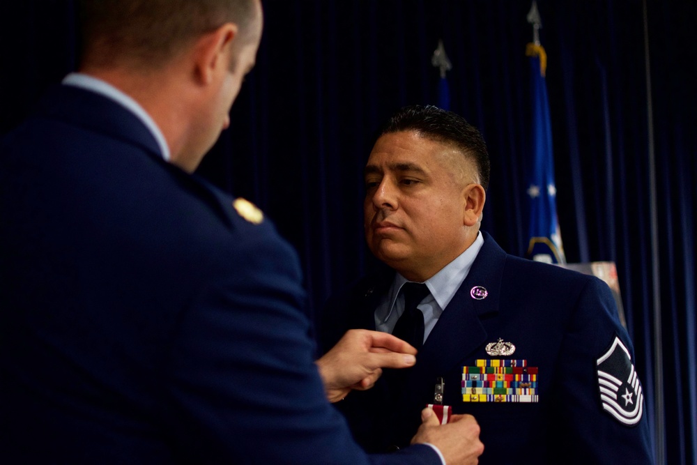 Maj. Gregory Green presents the Meritorius Service Medal to retiring Master Sgt. Bryan Sanchez