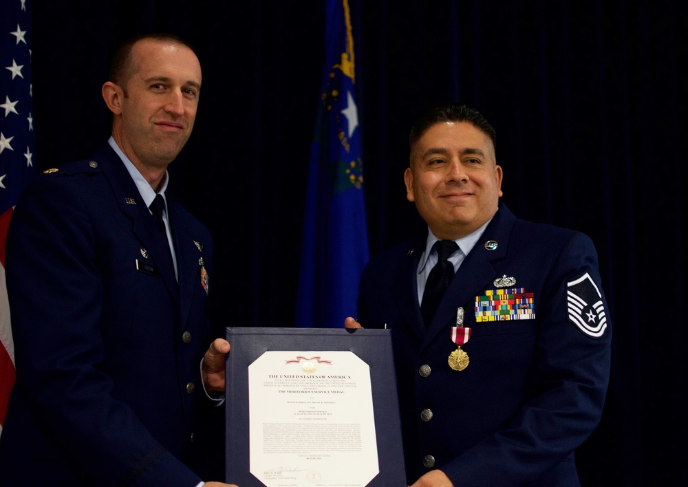 Maj. Gregory Green presents the Meritorius Service Medal to Master Sgt. Bryan Sanchez at his retirement
