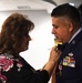 Master Sgt. Bryan Sanchez's wife, Tina Sanchez pins his retirement pin on his lapel