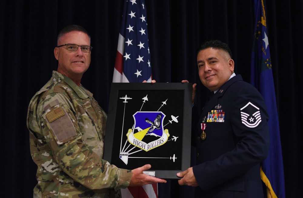 152nd Airlift Wing Command Chief, Chief Master Sgt. Mark Prizina presents the High Roller Mirror to Master Sgt. Bryan Sanchez