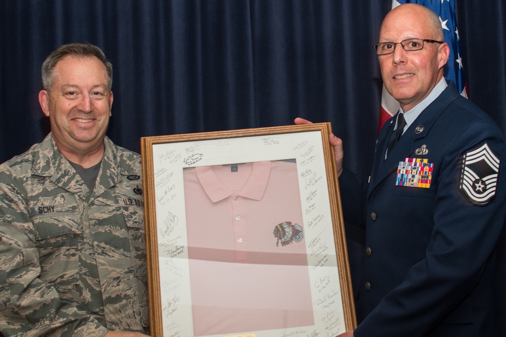 Chief Master Sgt. William Schy presents the &quot;pink polo&quot; to Chief Master Sgt. Terrance Hunt