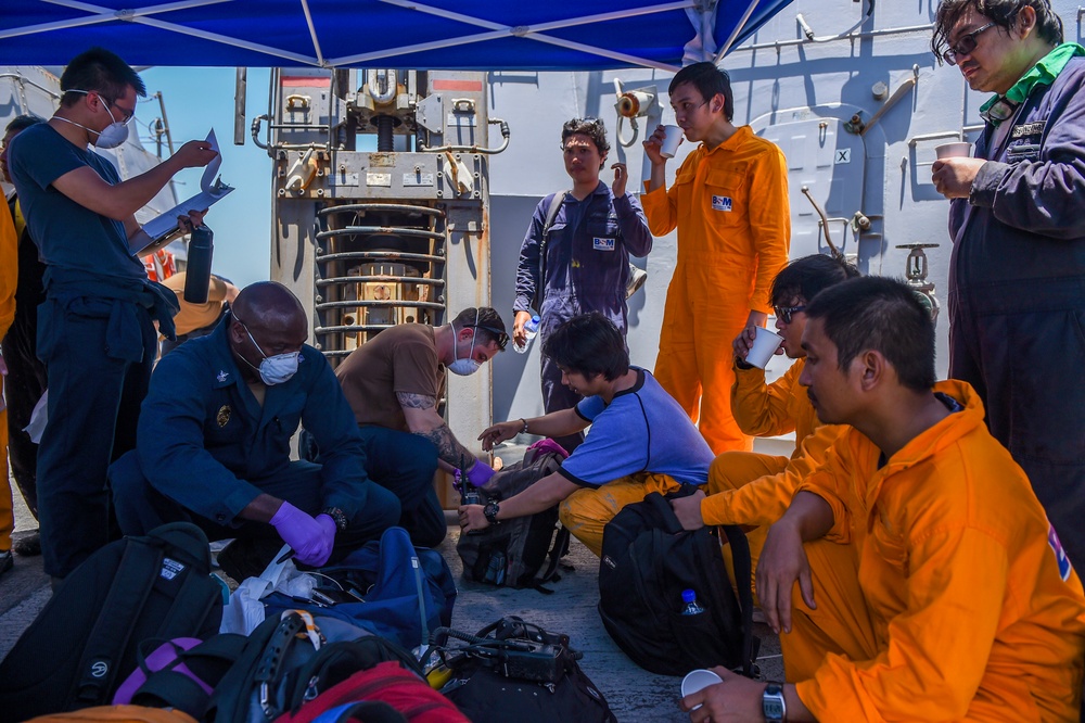 Sailors aboard the Arleigh Burke-class guided-missile destroyer USS Bainbridge (DDG 96) render aid to the crew of the M/V Kokuka Courageous