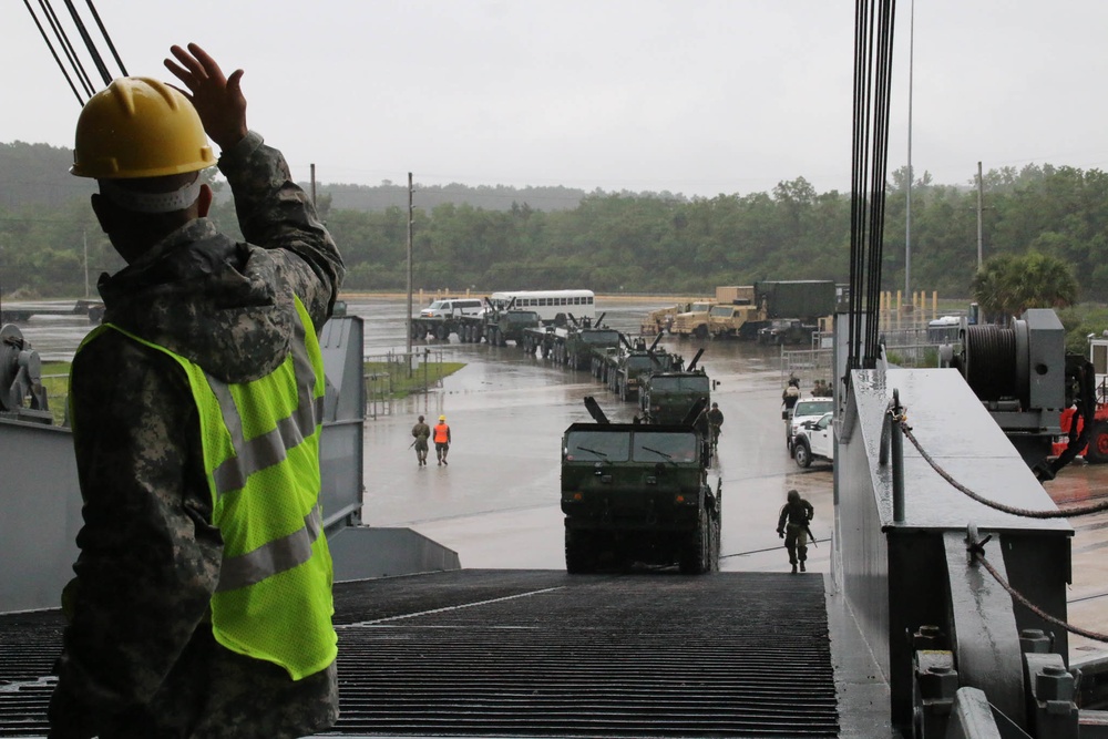 Soldiers and Marines load equipment aboard the U.S.N.S. Watkins (T-AKR 315) while moored at Wharf Alpha on Joint Base Charleston, South Carolina