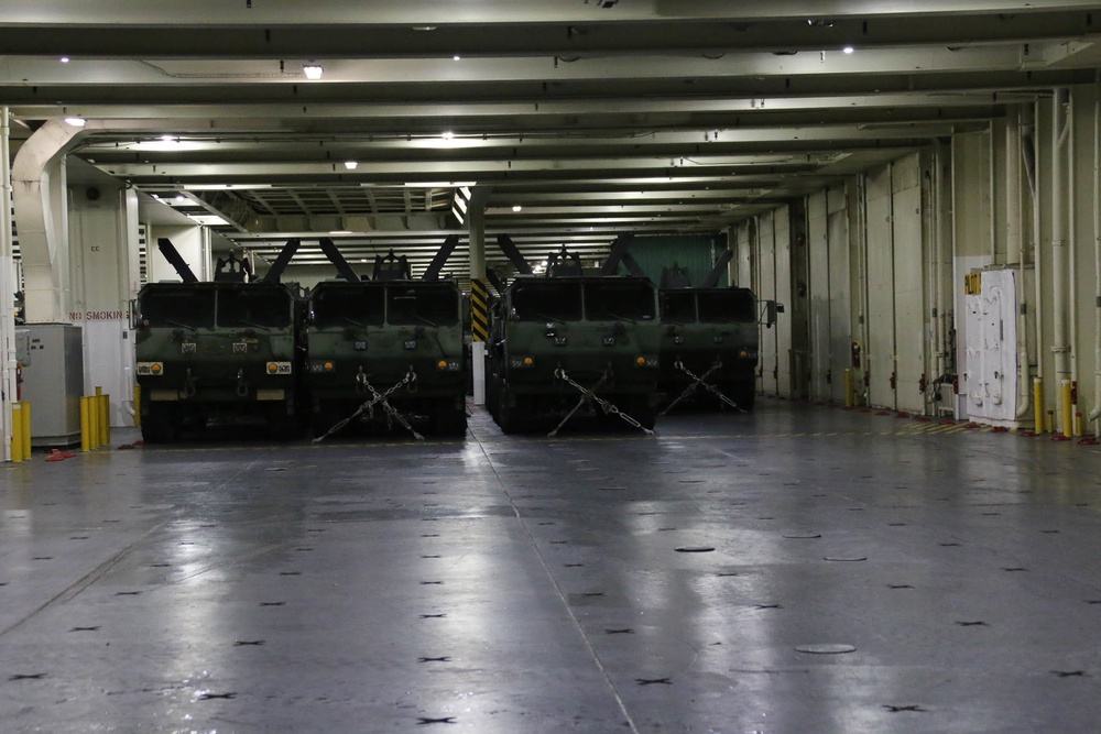 Soldiers and Marines load equipment aboard the U.S.N.S. Watkins (T-AKR 315) while moored at Wharf Alpha on Joint Base Charleston, South Carolina
