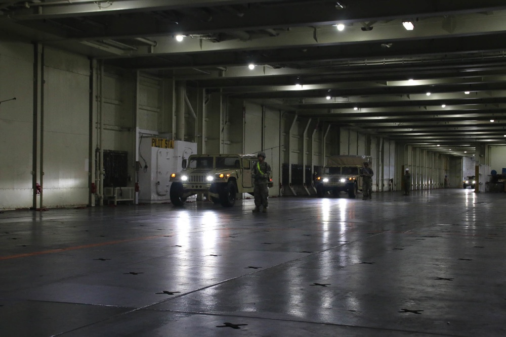 Soldiers and Marines load equipment aboard the U.S.N.S. Watkins (T-AKR 315) while moored at Wharf Alpha on Joint Base Charleston, South Carolina