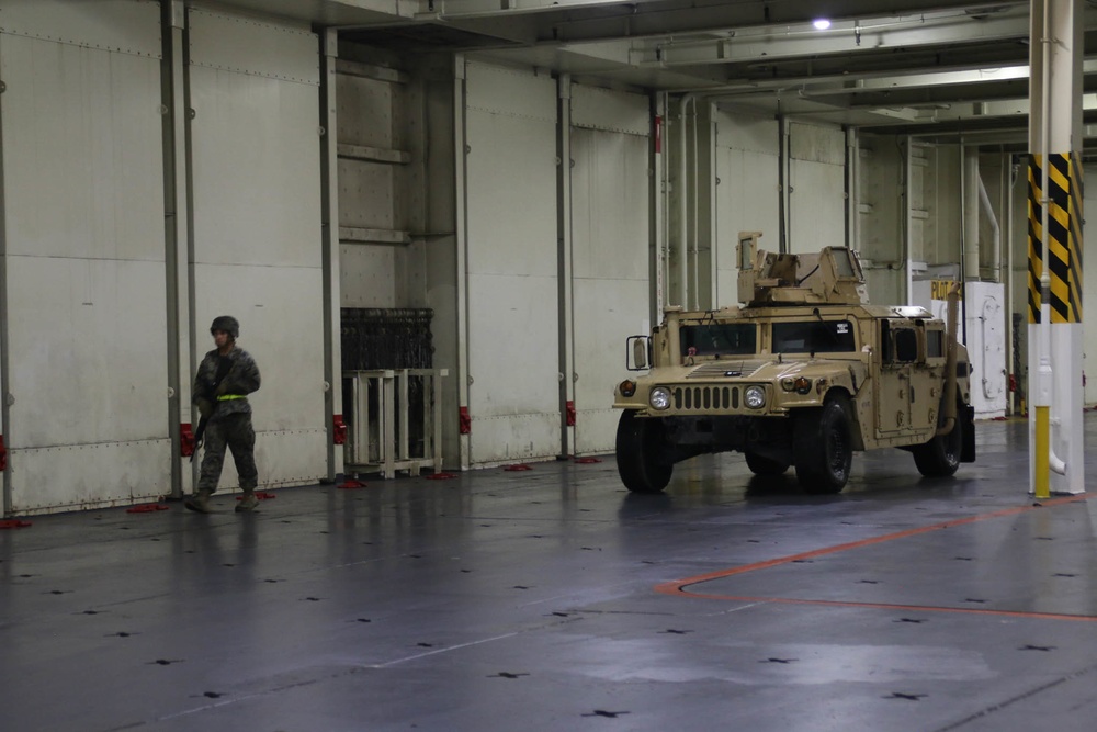 Soldiers and Marines load equipment aboard the U.S.N.S. Watkins (T-AKR 315) while moored at Wharf Alpha on Joint Base Charleston, South Carolina