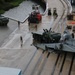 Soldiers and Marines load equipment aboard the U.S.N.S. Watkins (T-AKR 315) while moored at Wharf Alpha on Joint Base Charleston, South Carolina