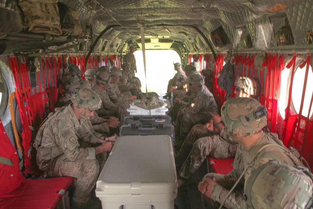 Soldiers rehearse safety procedures in a Chinook helicopter