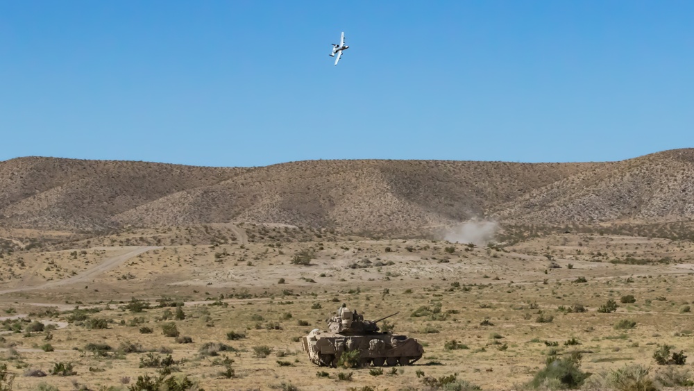 A-10 C Thunderbolt II flies over M1A2 Abrams at NTC