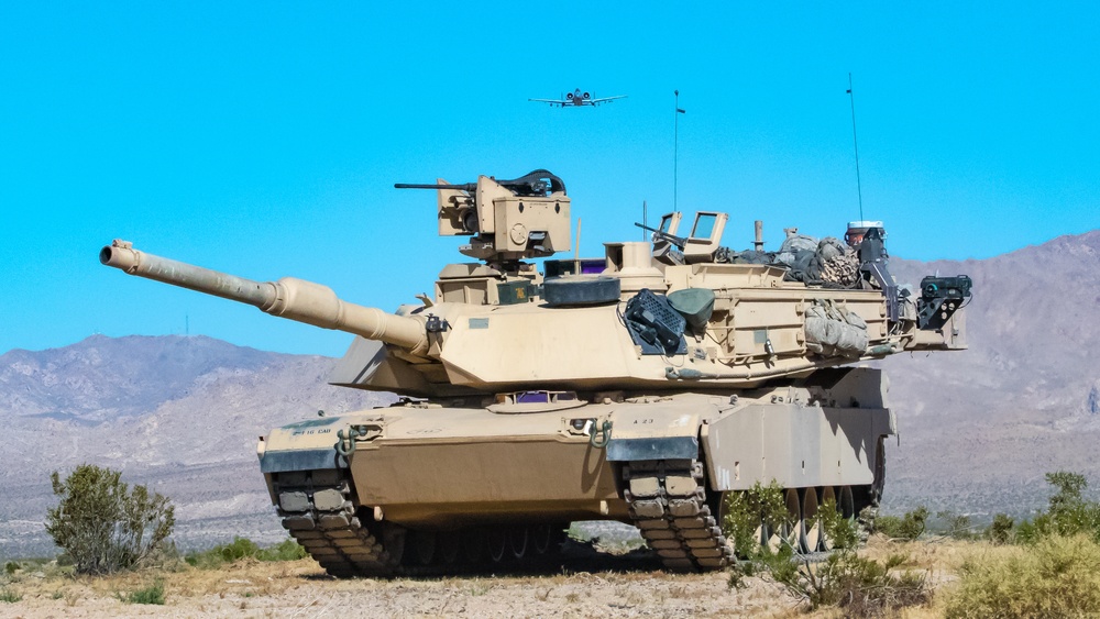 A-10 C Thunderbolt II flies over M1A2 Abrams at NTC