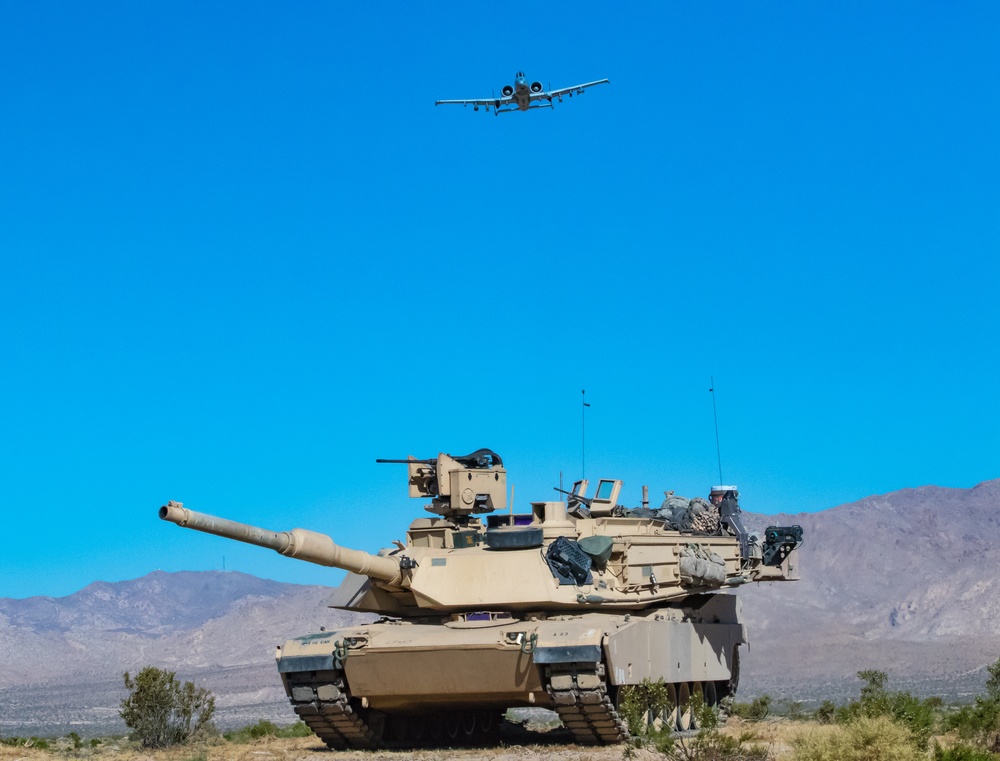 A-10 C Thunderbolt II flies over M1A2 Abrams at NTC