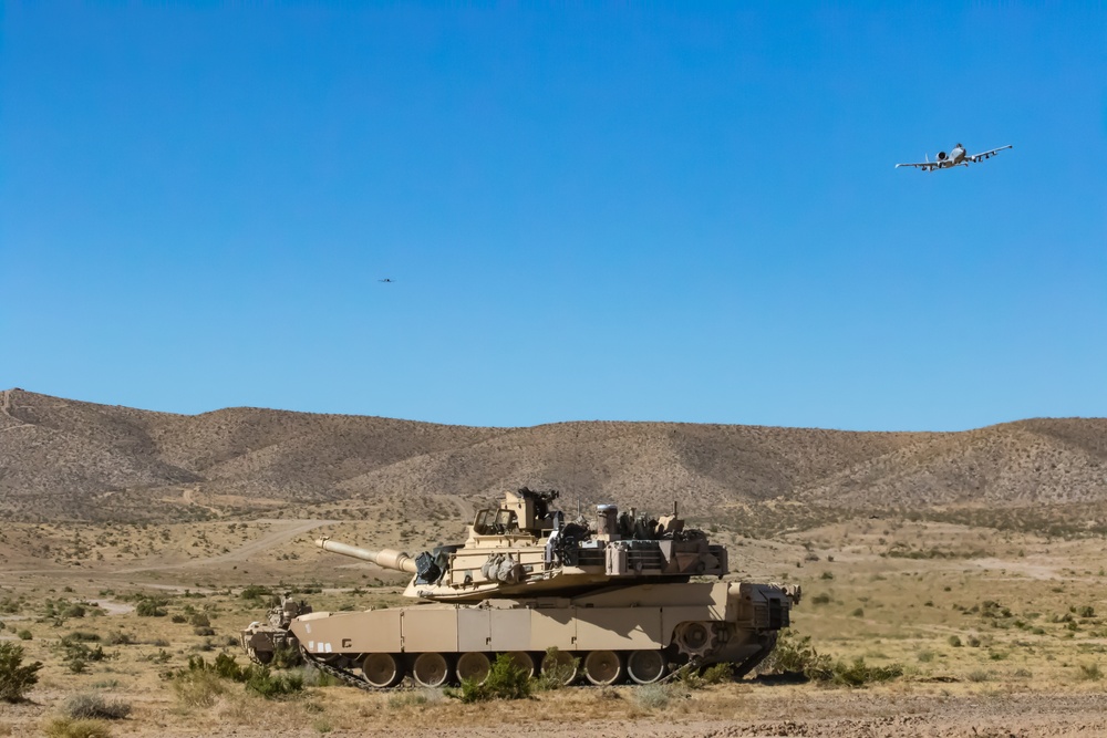 A-10 C Thunderbolt II flies over M1A2 Abrams at NTC