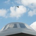 A F-22 Raptor flies about a B-2 at Wings Over Whiteman Air and Space Show