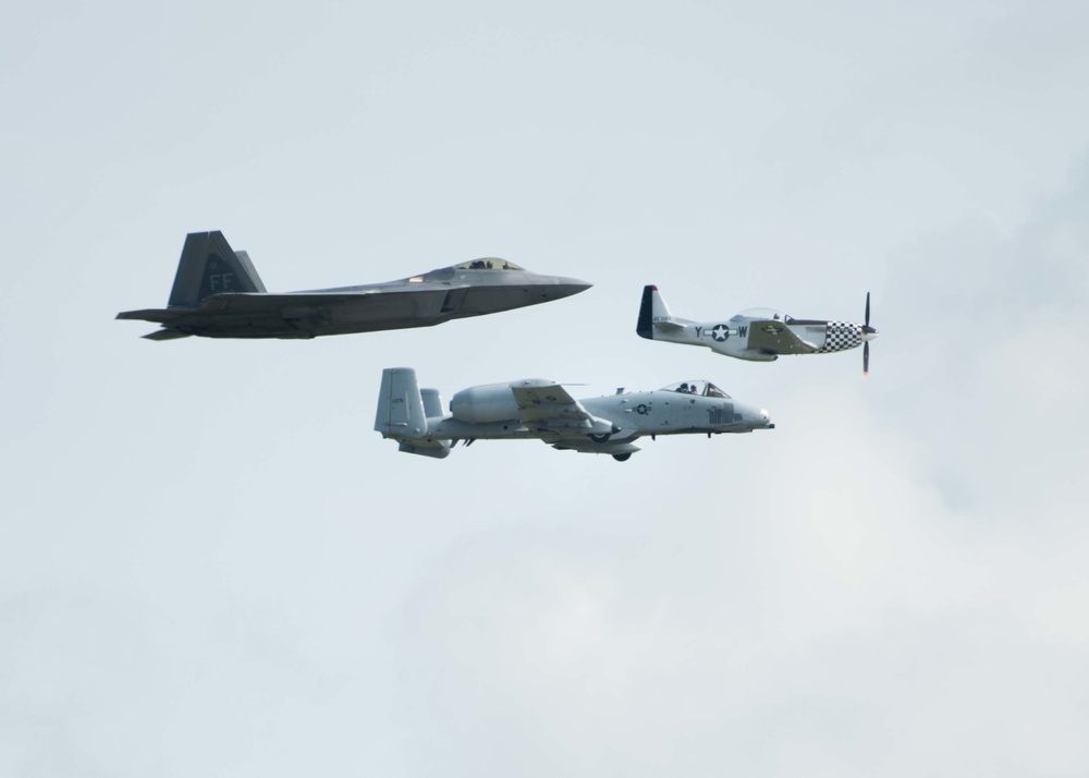 A F-22 Raptor, P-51D Mustang and an A-10 Thunderbolt II fly in a formation at Wings Over Whiteman