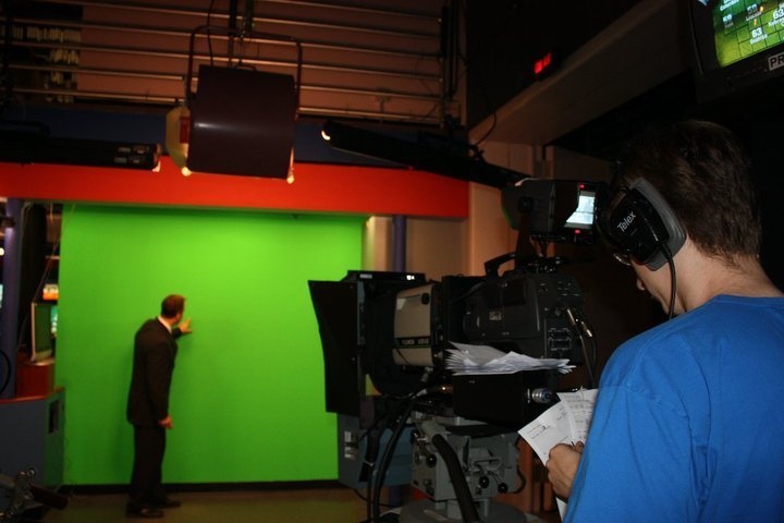 Omaha District meteorologist forecasts weather in front of a green screen