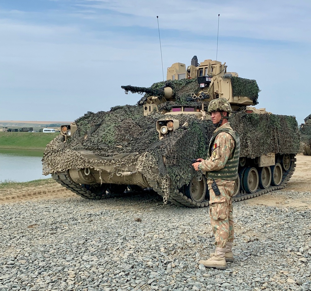 Romanian Soldier directs Bradley Fighting Vehicle