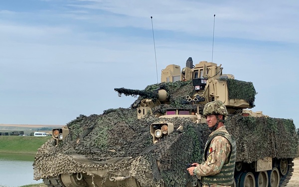 Romanian Soldier directs Bradley Fighting Vehicle