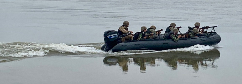 Romanian Soldiers maneuver an inflatable bombard raft across the Danube River