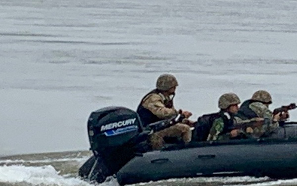 Romanian Soldiers maneuver an inflatable bombard raft across the Danube River