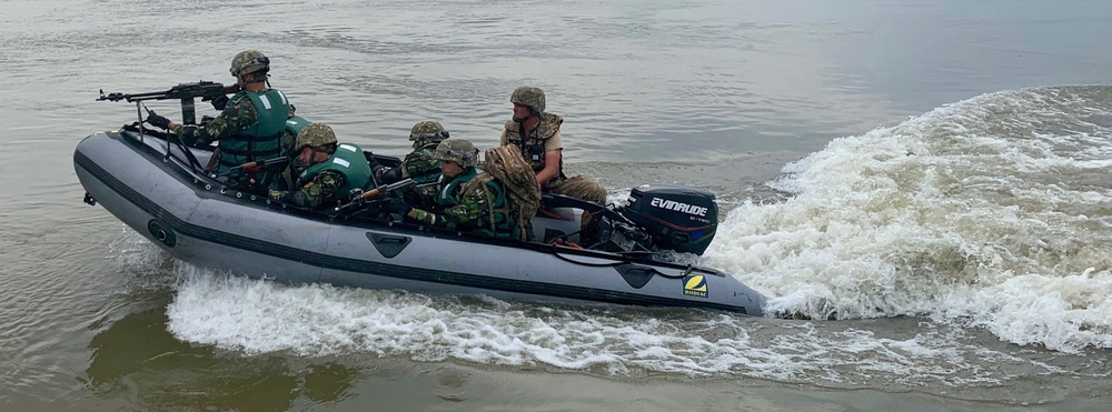Romanian Soldiers maneuver a raft across the Danube River