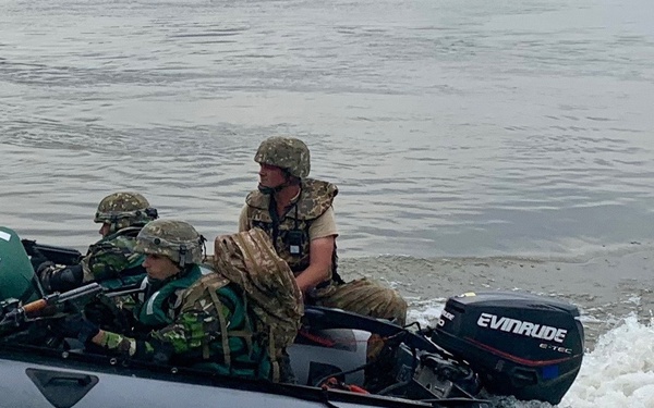Romanian Soldiers maneuver a raft across the Danube River