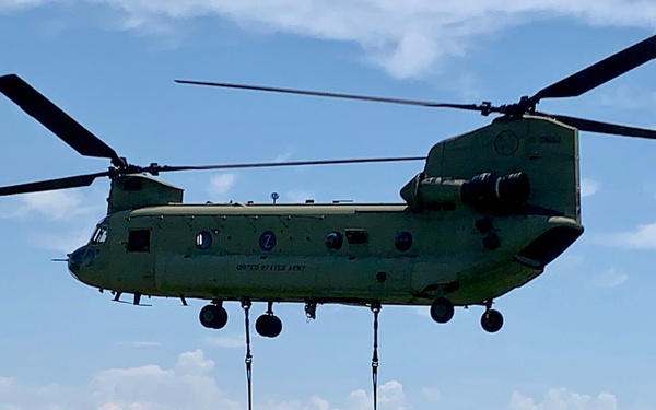 Chinook lifts raft for wet gap crossing exercise during Saber Guardian 19