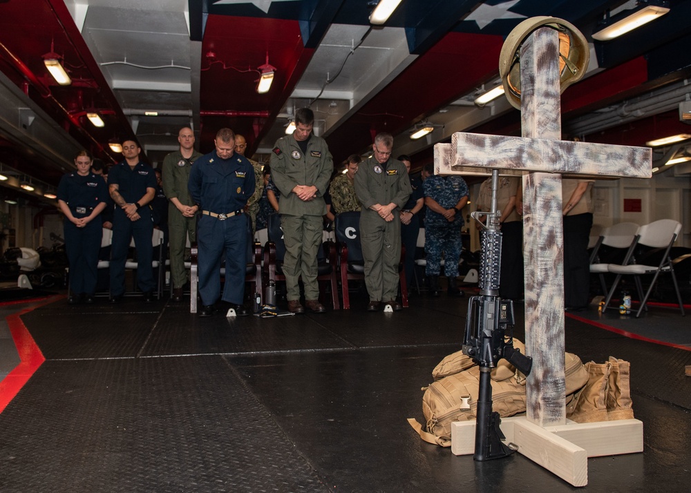 U.S. Sailors assigned to the aircraft carrier USS John C. Stennis (CVN 74) observe a moment of silence during a celebration of the 121st birthday of the Hospital Corpsman rating