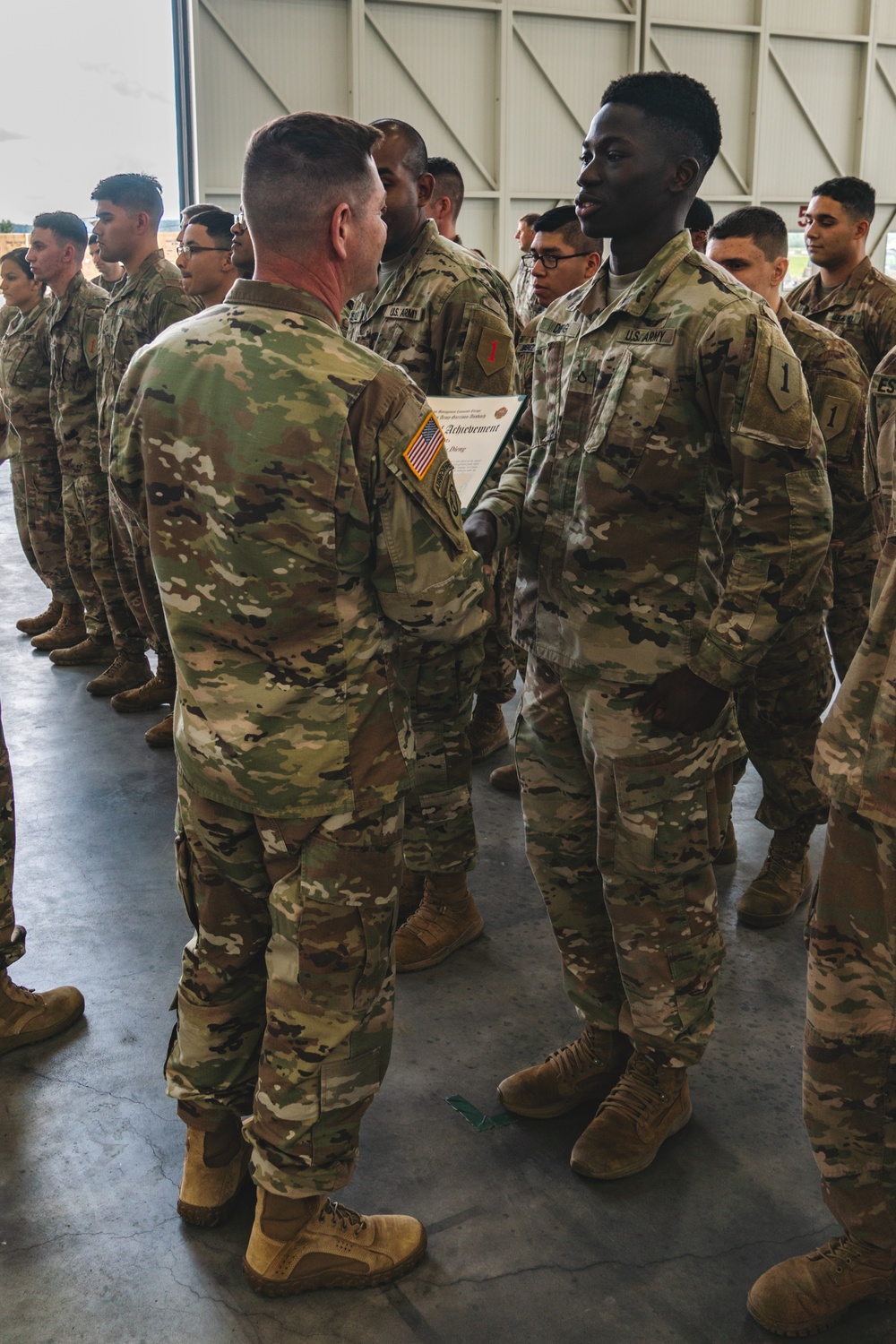 Col. Steven Pierce gives a 1CAB Soldier a certificate of Appreciation for participating in the full scale Garrison Exercise.