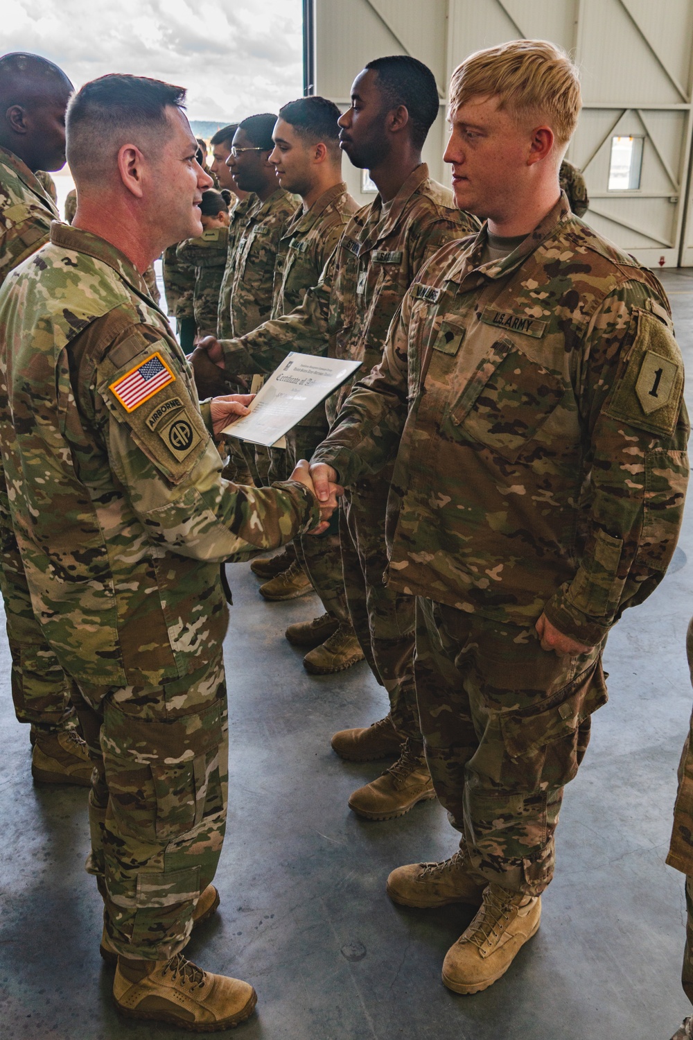 Col. Steven Pierce gives a 1CAB Soldier a certificate of Appreciation for participating in the full scale Garrison Exercise.