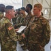 Col. Steven Pierce gives a 1CAB Soldier a certificate of Appreciation for participating in the full scale Garrison Exercise.