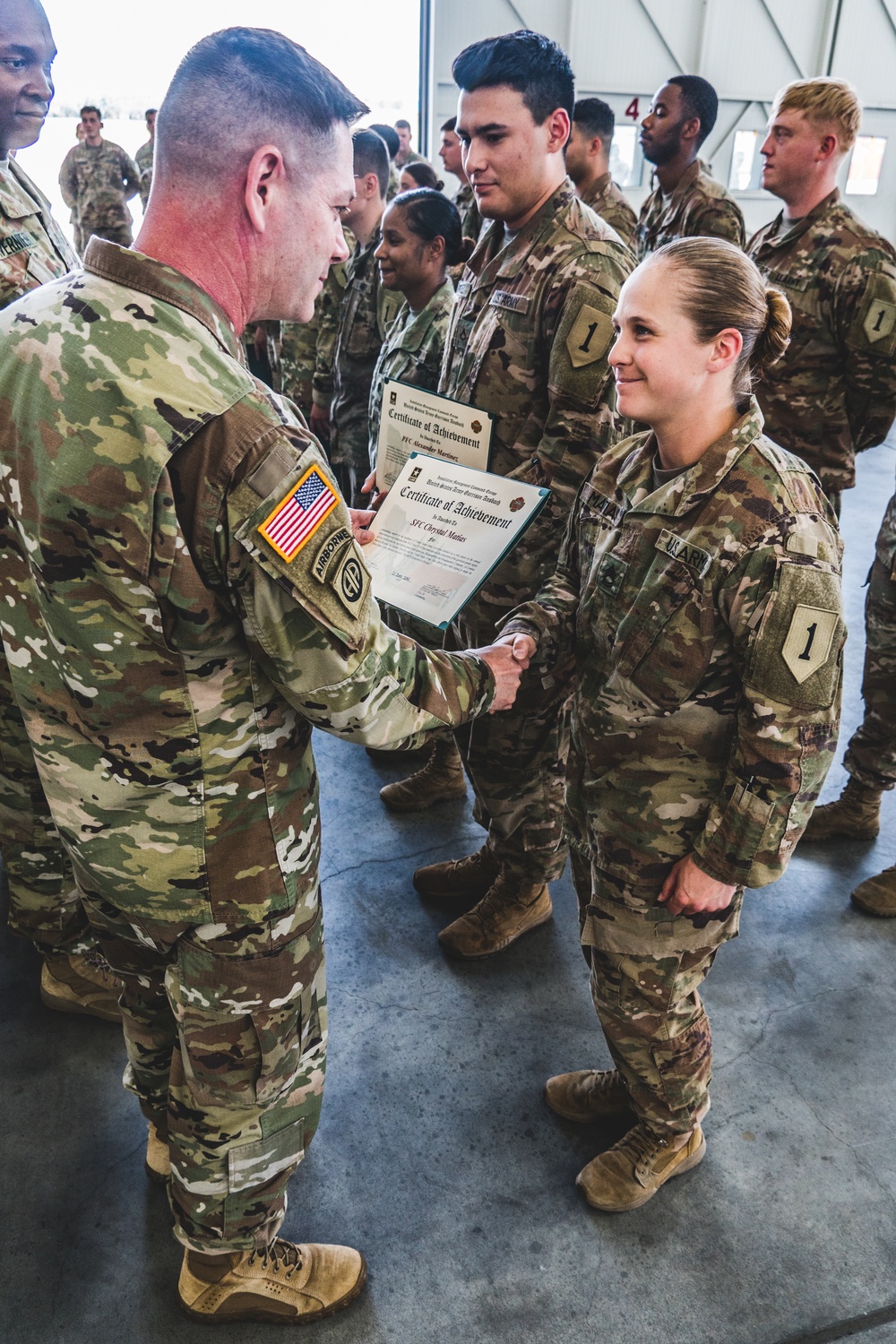 Col. Steven Pierce gives a 1CAB Soldier a certificate of Appreciation for participating in the full scale Garrison Exercise.