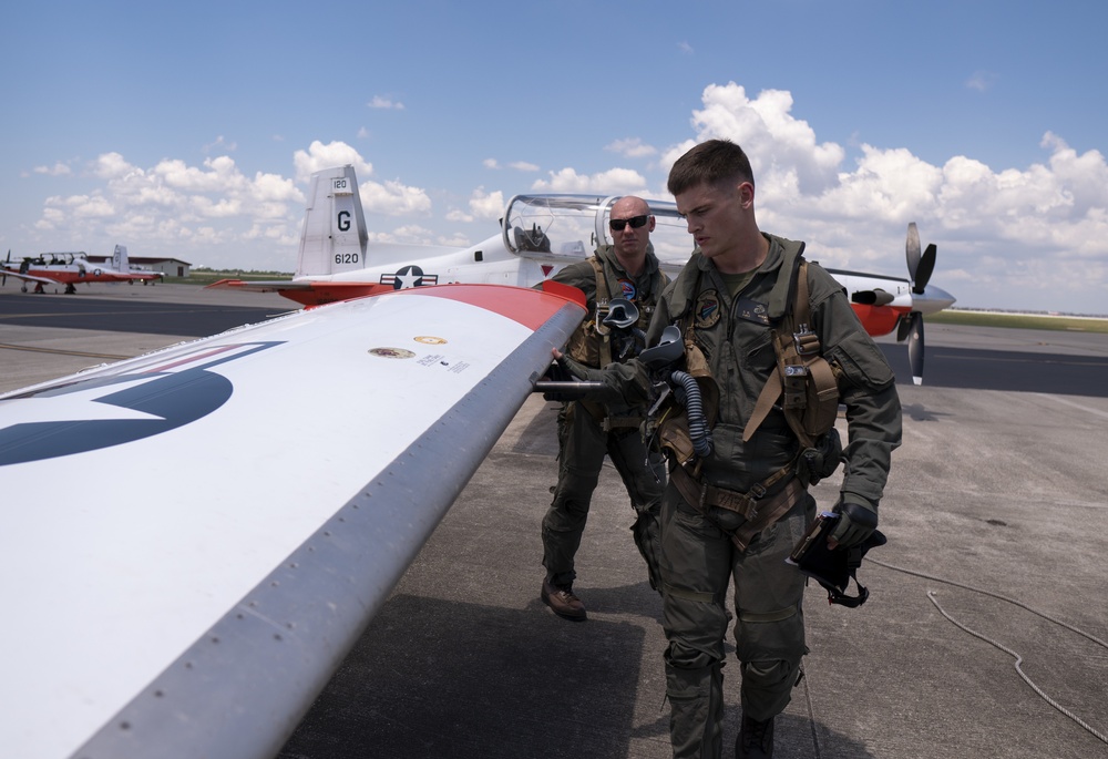 A student and instructor pilot perform preflight inspection before student's first flight