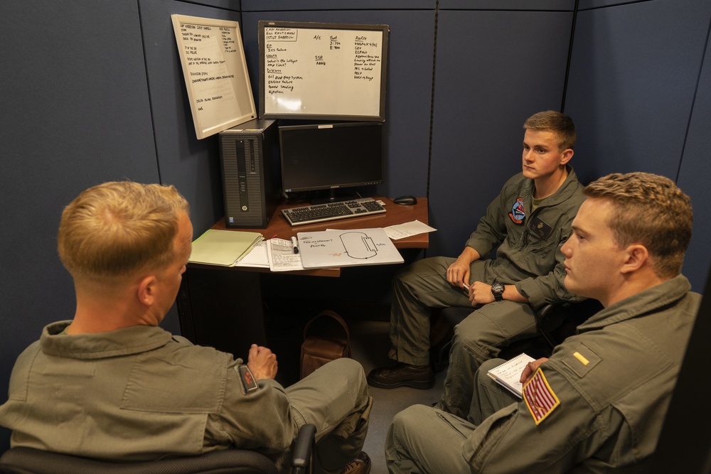 Two Student pilots perform preflight NATOPS brief with their instructor pilot