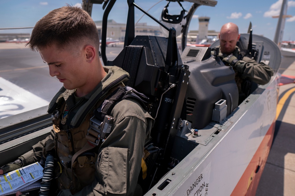 Student pilot reviews checklist prior to his first flight in a T-6B Texan II aircraft