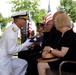 Rear Adm. John Schommer presents a folded flag to a nephew of Navy Fireman 1st Class Angelo M. Gabriele.
