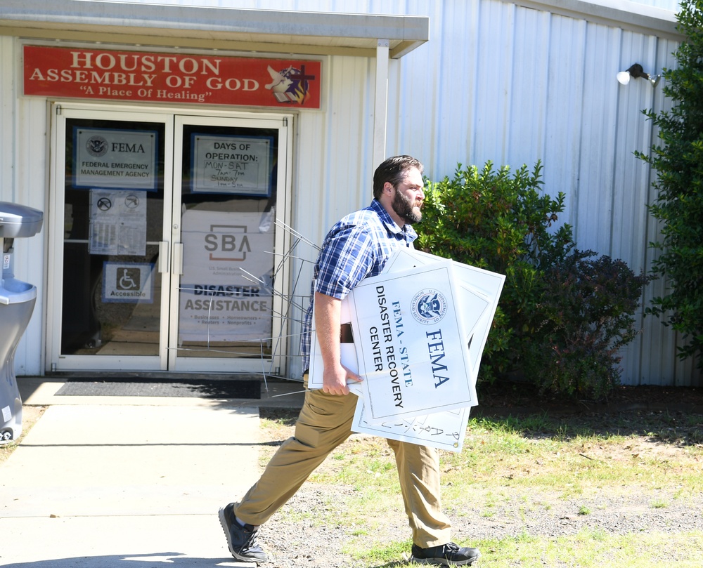 A FEMA Representative Adds Signage at a Disaster Recovery Center