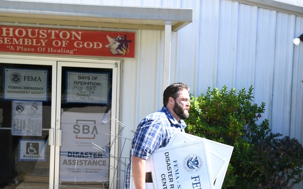 A FEMA Representative Adds Signage at a Disaster Recovery Center