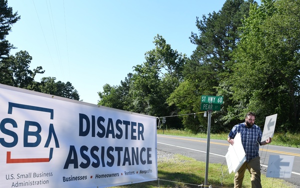 A FEMA Representative Adds Signage at a Disaster Recovery Center