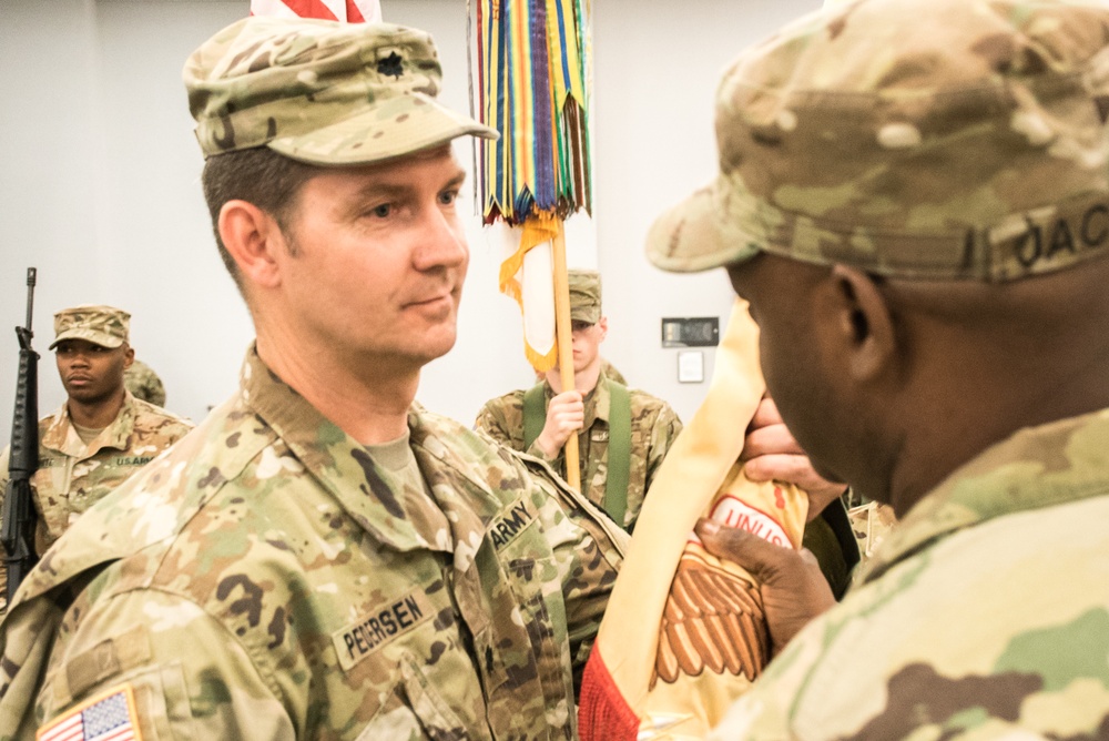 Incoming Battalion Commander, Lt. Col. Seth C. Pedersen, receives the unit’s flag from the 518th Brigade Commander, Col. Gerry Jackson,