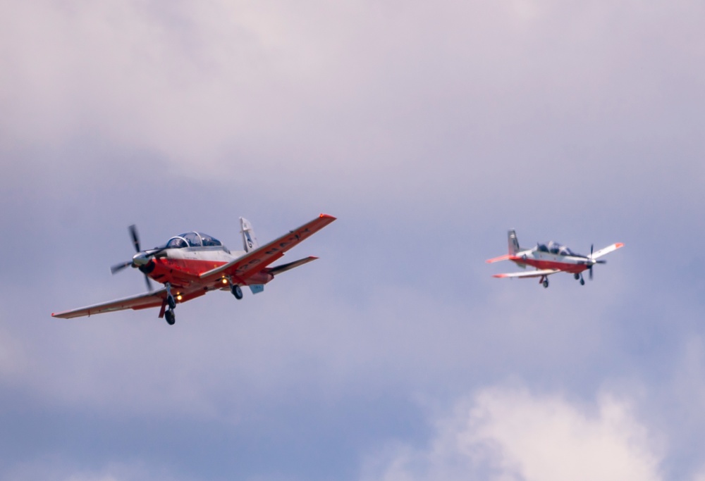 Two Navy T-6B Texan II aircraft prepare to land during a formation flight