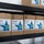 The image shows multiple cardboard boxes of Renown Citrus Quat 64 Disinfectant Cleaner stacked on black metal wire shelving units. The boxes are labeled with product code REN02846-MS and include hazard warnings such as 'DANGER' and 'KEEP OUT OF REACH OF CHILDREN'. This appears to be a storage room or warehouse stocking commercial cleaning supplies.
