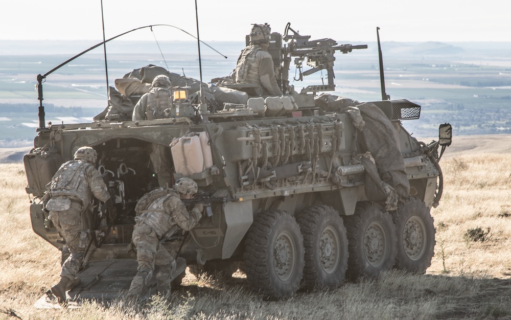 Soldiers mount a Stryker while conducting zone reconnaissance training