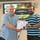 U.S. Transportation Command holds training on TMS prototype at Fort McCoy Two men are shaking hands while jointly holding a certificate in what appears to be a conference or training room. The certificate is issued to 'Anthony Reeves' and appears to be from a Transportation Management System (TMS) program. In the background, a presentation screen displays 'Data Capture TMS Prototype, Ft McCoy' with U.S. Army branding.