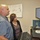 U.S. Transportation Command holds training on TMS prototype at Fort McCoy Two individuals, a man and a woman, are standing at a standing desk workstation reviewing information on dual computer monitors. They appear to be in an office or classroom environment with a whiteboard visible on the wall behind them containing handwritten notes and a diagram. The setting suggests a professional or educational workspace.